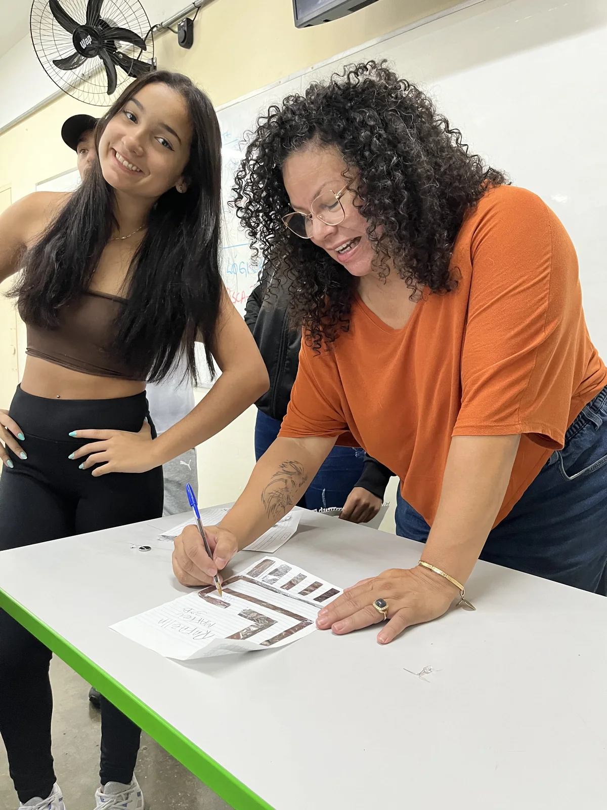 Renata Kelly acompanha uma estudante durante uma atividade do Projeto Kriar